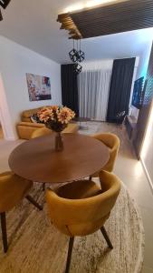 uma sala de estar com uma mesa e cadeiras amarelas em Anika Sweet Apartment at Vodno em Skopje