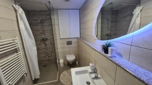 ein Bad mit einem Waschbecken und einem Spiegel in der Unterkunft Anika Sweet Apartment at Vodno in Skopje