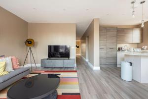 a living room with a couch and a tv at Luxury London Garden Flat in London