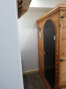 a hallway with a black door and a wooden cabinet at Chalet Les Garands in Valmeinier