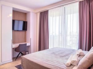 ein Hotelzimmer mit einem Bett und einem großen Fenster in der Unterkunft BW Aurora 108 in Belgrad