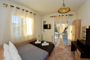 a bedroom with a bed and a large window at Bastasio airport skg in Tagarades