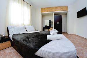 a bedroom with a large bed with towels on it at Bastasio airport skg in Tagarades