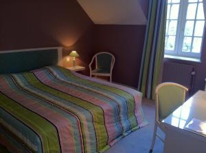 1 dormitorio con 1 cama, mesa y sillas en Logis La Marjolaine, en Moulay