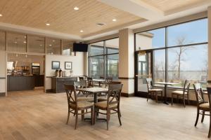 a dining room with tables and chairs and windows at Country Inn & Suites by Radisson, Bemidji, MN in Bemidji