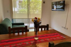 un vase de fleurs assis sur une table en bois dans l'établissement Departamento 2 amb luminoso confortable Terraza y pileta compartidas, à Buenos Aires