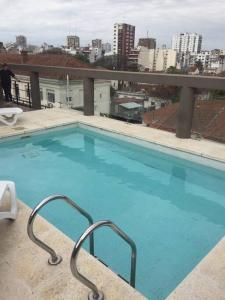 - une grande piscine bleue au-dessus d'un bâtiment dans l'établissement Departamento 2 amb luminoso confortable Terraza y pileta compartidas, à Buenos Aires