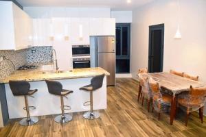 Breeze Apartments في نادي: مطبخ مع طاولة خشبية ومطبخ مع غرفة طعام