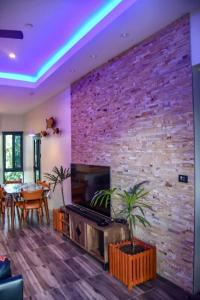 a living room with a brick wall and a pool table at Breeze Apartments in Nadi