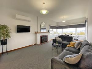 a living room with a couch and a fireplace at Bella Vista on Beach in Hobart