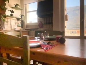 un tavolo in legno con un piatto e bicchieri da vino sopra di Il VagaMondo a Rovereto