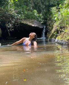 uma mulher na água perto de uma cascata em Aconchego no Campo em São Roque