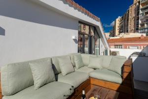 a couch sitting on top of a balcony at Luxury Duplex with Pool and Padel Court in Town by AlohaMálaga in Málaga