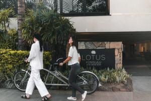 dos mujeres caminando en bicicleta delante de un edificio en Lotus Honolulu at Diamond Head en Honolulu