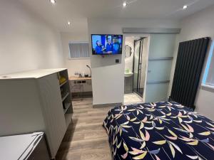 a bedroom with a bed and a tv on a wall at Pembrokeshire Holiday Accommodation in Pembrokeshire