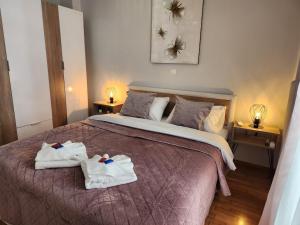 Un dormitorio con una cama con toallas. en Kallithea Gold Apartment greendom, en Atenas
