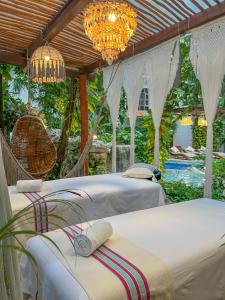 a group of beds in a room with a pool at Casita del Mar in Playa del Carmen