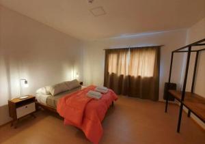 1 dormitorio con 1 cama con manta roja en Casa Las Lengas en Ushuaia