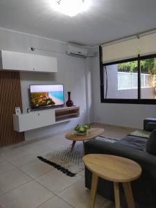 sala de estar con sofá y TV en la pared en Lake 360 Apart Villa Carlos Paz en La Cuesta