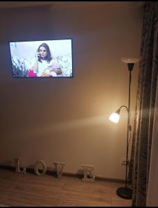einen Flachbild-TV an der Wand im Wohnzimmer in der Unterkunft Delux Flat Straja-Lupeni in Lupeni