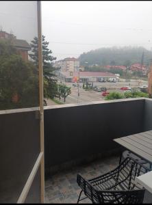 einen Balkon mit einem Tisch und Blick auf einen Parkplatz in der Unterkunft Delux Flat Straja-Lupeni in Lupeni