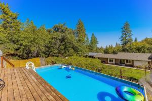 una piscina al aire libre con terraza y una casa en Wildcat Family Ranch, en Murphys