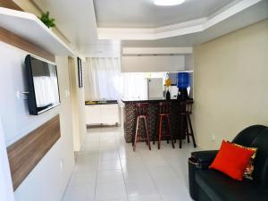 a living room with a couch and a kitchen at Apartamento Na Praia do Guaibim - Valença-Ba in Guaibim