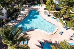 an overhead view of a pool with chairs and palm trees at Luxury Beachfront Family-Friendly Condo in Hollywood