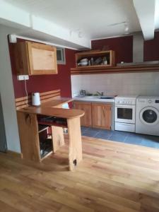 eine Küche mit Holztisch und Herd in der Unterkunft appartement avec cachet au coeur de Vals les bains in Vals-les-Bains