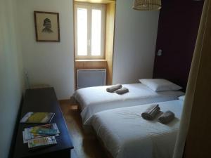 zwei Betten in einem Hotelzimmer mit Handtüchern darauf in der Unterkunft appartement avec cachet au coeur de Vals les bains in Vals-les-Bains
