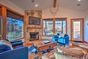 a living room with blue furniture and a stone fireplace at Updated Cabin with 360-Degree Mtn View 1 Mi to Lake in Medicine Park
