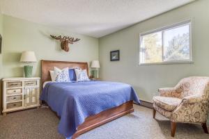 a bedroom with a bed and a chair and a window at Ski House 106 - Meredith Lodging in Bend +26 photos