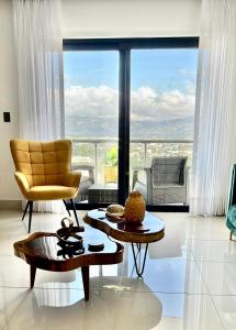a living room with a yellow chair and a large window at Top Floor in Luxury Tower in Santiago de los Caballeros