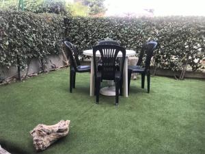 una mesa y sillas en la hierba con un tronco en Appartement Port-la-Nouvelle, 2 pièces, 4 personnes - FR-1-229C-194, en Port-la-Nouvelle