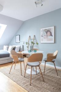 a dining room with four chairs and a table at TurnKey I Angelo Roma Apartments in Prague