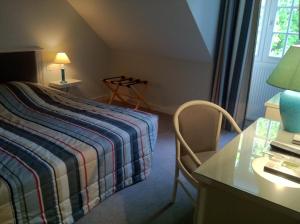 a bedroom with a bed and a desk and a table at Logis La Marjolaine in Moulay +5 photos