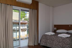 ein Schlafzimmer mit einem Bett und einem großen Fenster in der Unterkunft Solar das Águas - HOTEL in Marcelino Ramos
