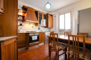 a kitchen with wooden cabinets and a table and chairs at Griffoni Home, in the Heart of the City in Bologna