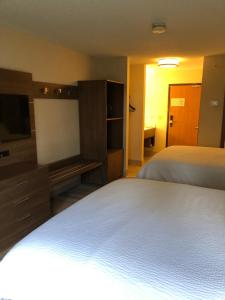 a bedroom with a bed and a flat screen tv at Holiday Inn Express Mt. Vernon, an IHG Hotel in Mount Vernon