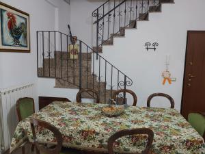 ein Esszimmer mit einem Tisch und einer Treppe in der Unterkunft Casa Elsa in Palidoro