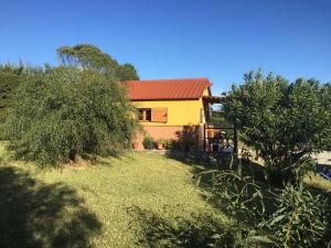une maison jaune avec un toit rouge dans une cour dans l'établissement Rosa de la contrera, à Tarifa