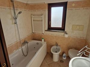 ein Badezimmer mit Badewanne, Toilette und Waschbecken in der Unterkunft Casa Elsa in Palidoro + 26 Fotos