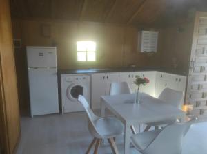 une cuisine avec une table et des chaises ainsi qu'un lave-linge dans l'établissement Rosa de la contrera, à Tarifa
