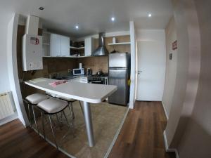 a kitchen with a white counter and a refrigerator at El Descanso - Ushuaia in Ushuaia +14 photos