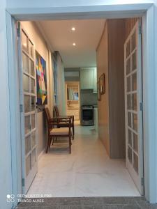 un pasillo con una puerta que da a una cocina con mesa en Flat Residencial Simas, en Florianópolis