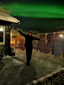 a woman standing in the snow with her arms outstretched at Aurora rooms for rent nr2 We are doing privet Northen lights trips, reindeer trip and Fjord sommaroy trip in Tromsø