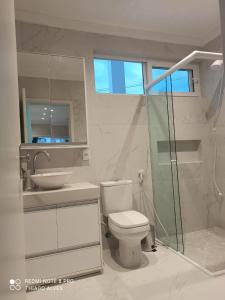 een badkamer met een toilet, een wastafel en een douche bij Flat Residencial Simas in Florianópolis