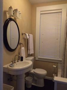 een badkamer met een wastafel, een toilet en een spiegel bij Your home away from home! First floor LTR discounts 533 in Pittsburgh