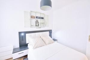 - une chambre avec un lit blanc et une tête de lit noire dans l'établissement Paris La Villette - Charming Apartment 2 rooms, à Paris