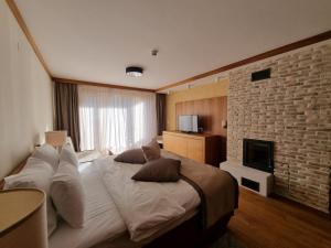 a bedroom with a large bed and a brick wall at Apartman aparthotel Vučko in Jahorina